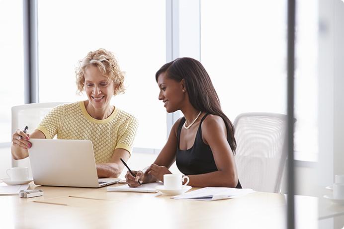 a woman and a man looking at a laptop