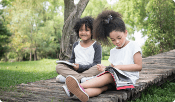 a couple of children sitting on a stone bench