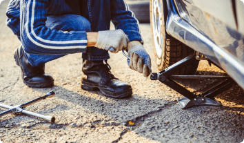 someone using a jack to fix a car