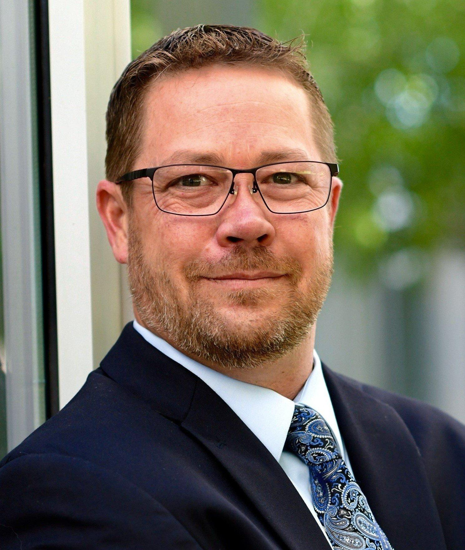 a man wearing glasses and a suit