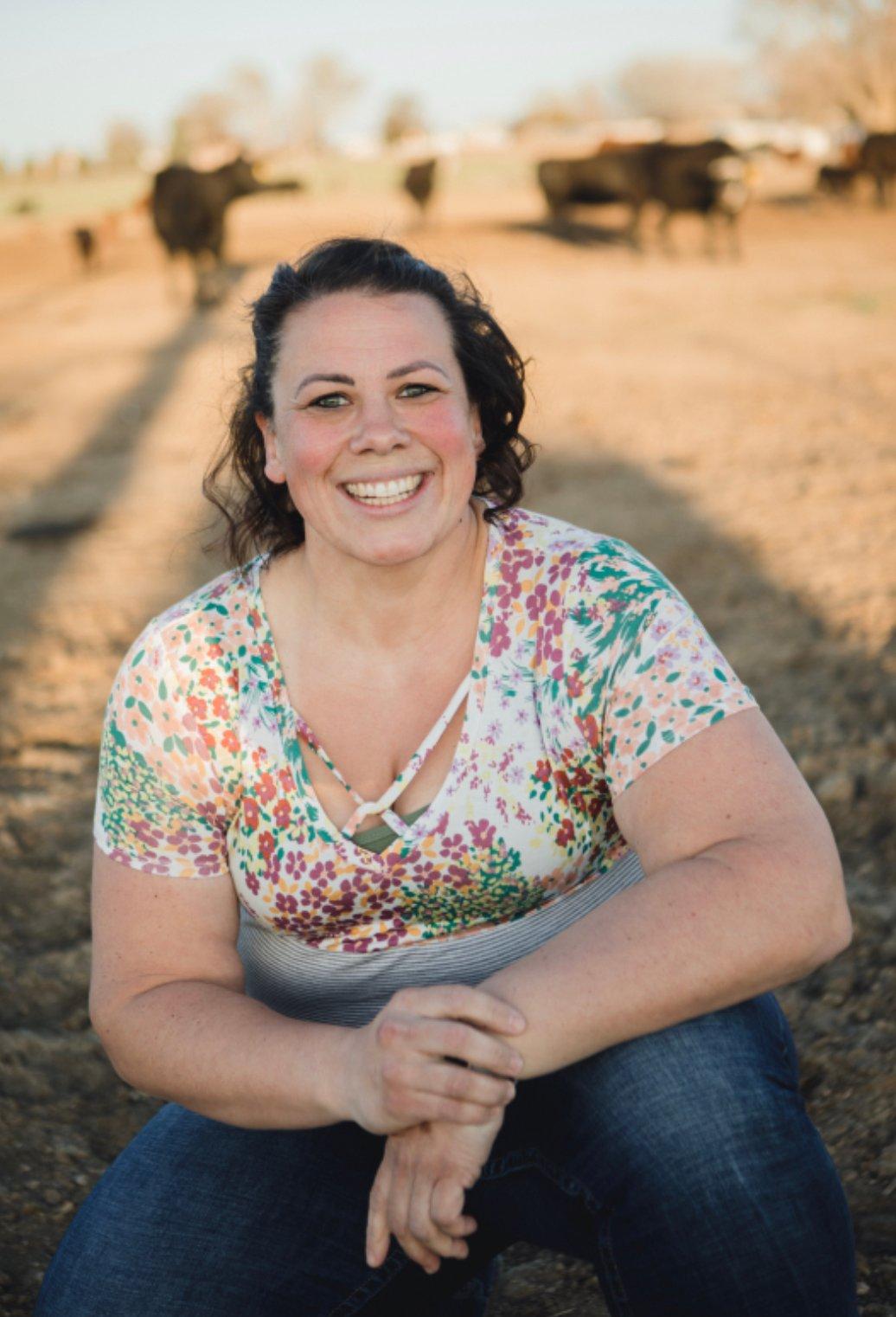 a person sitting in front of a herd of cattle