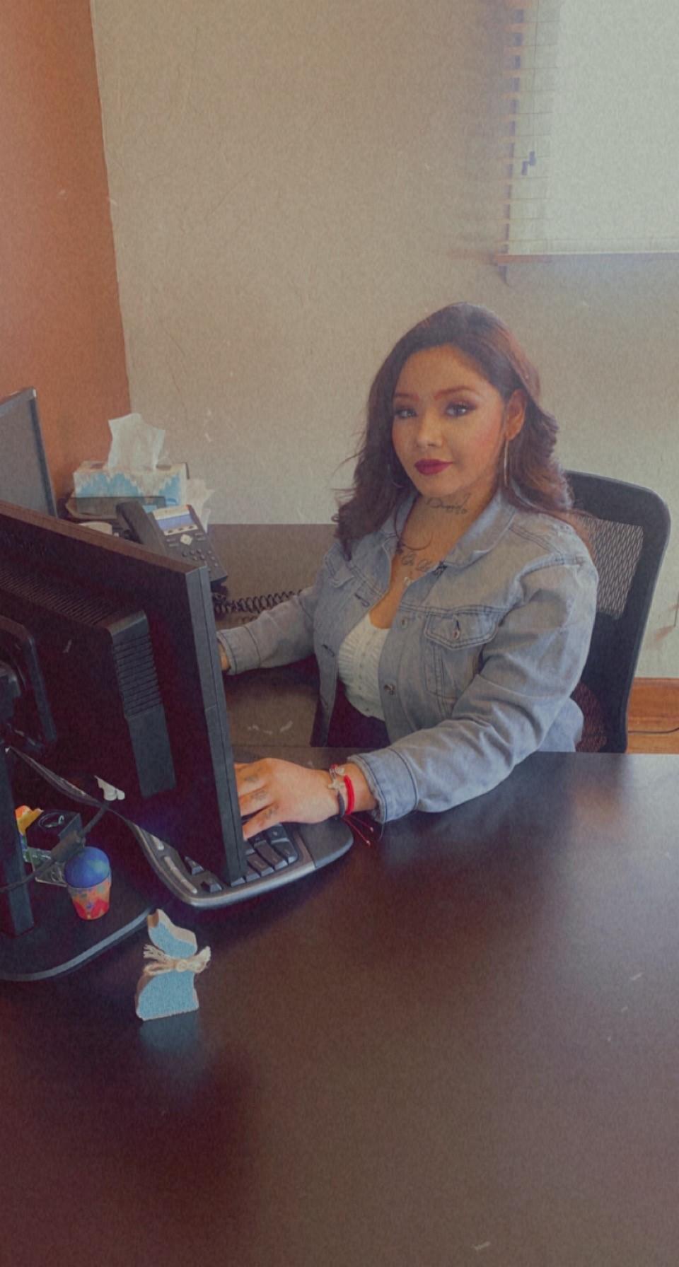 a woman sitting at a table with a laptop