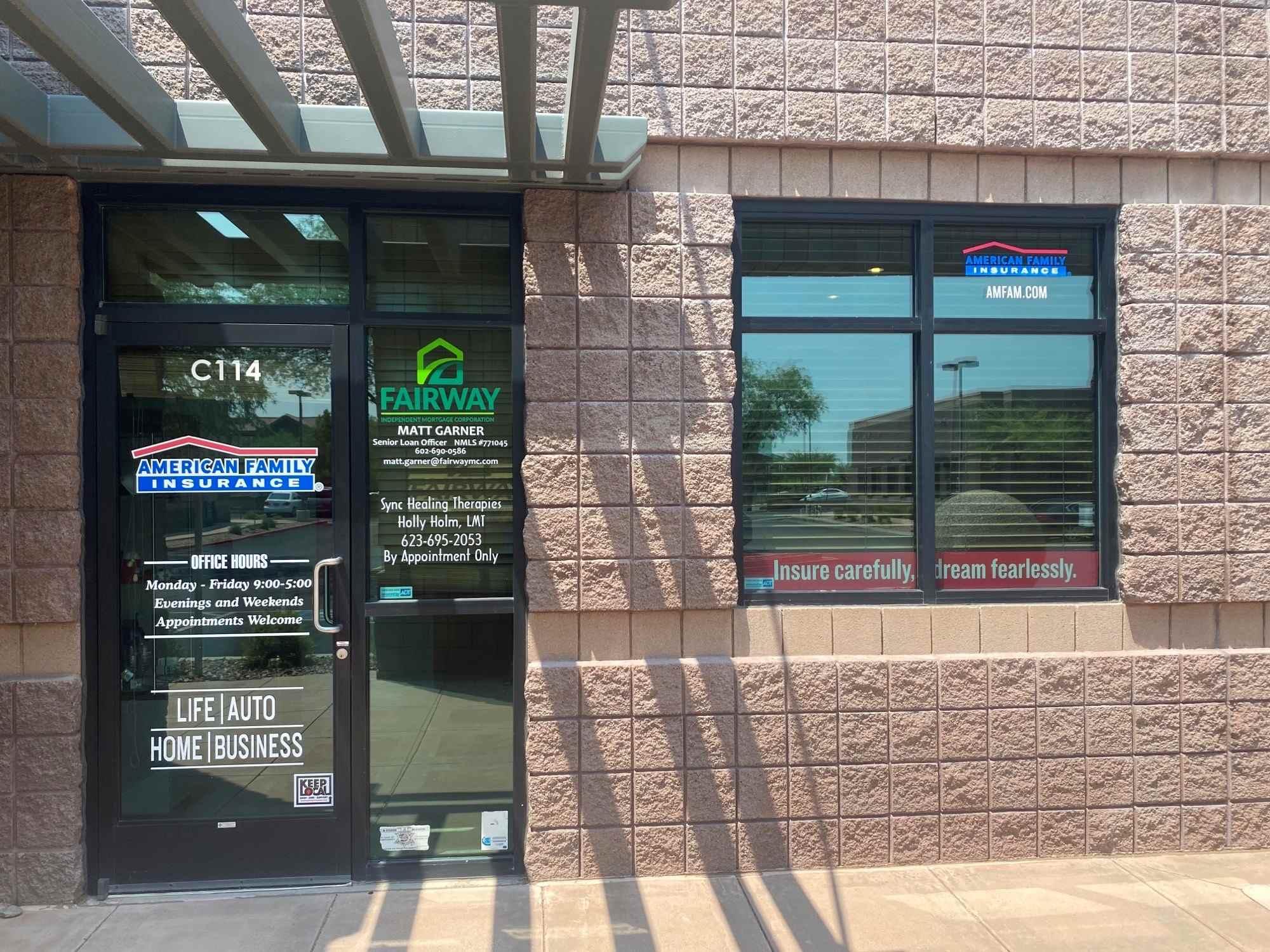 a building with a glass door and a window with a sign on it