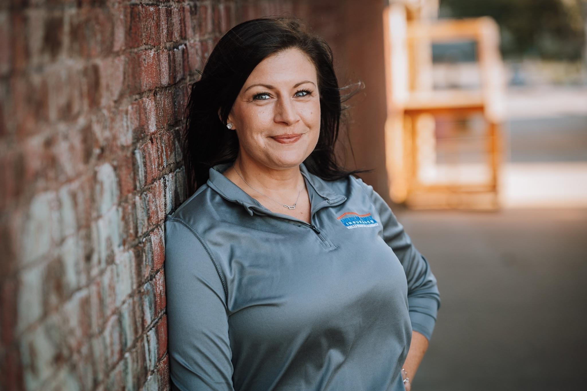 a person standing next to a brick wall