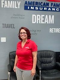 a woman standing in front of a wall with a sign on it