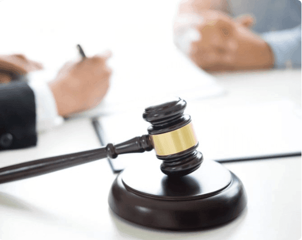 Judge sitting at desk with another person. 