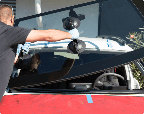 Mechanic replaces a car's windshield. 