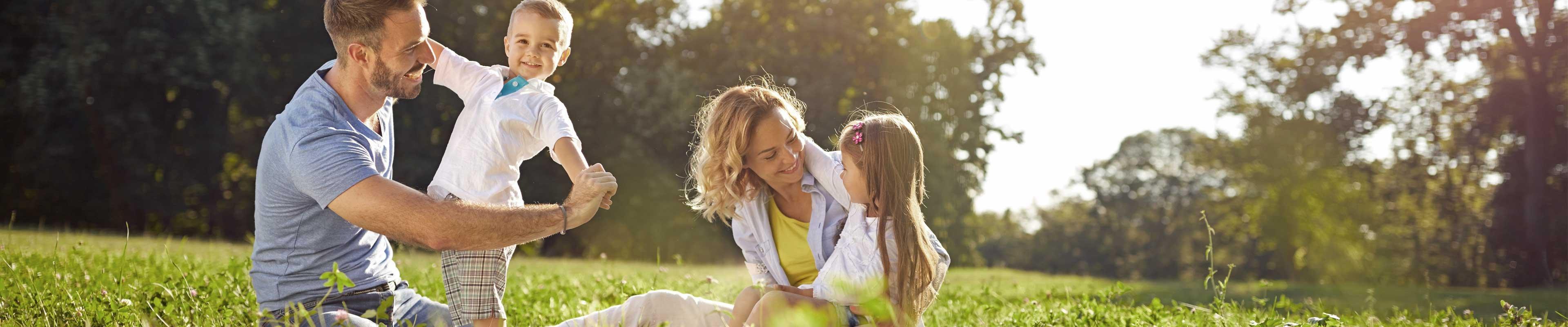 American Family Insurance parents and two kids in grass