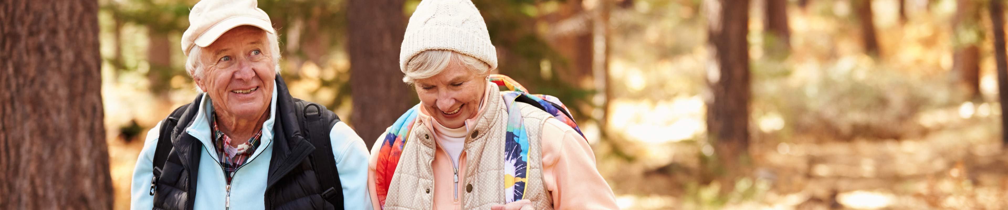 Elderly couple walking in the woods. 