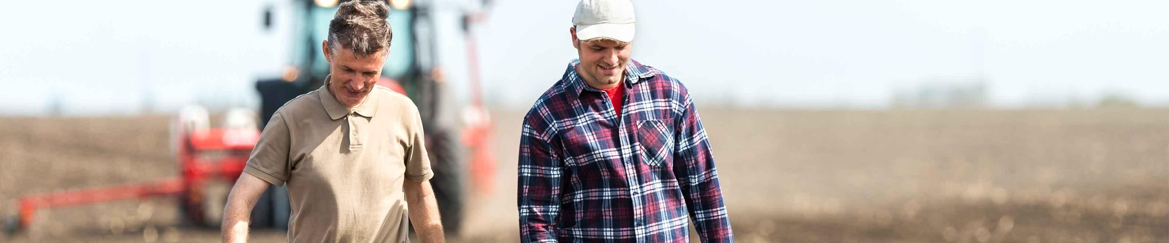 Dad and Son Walking with farm and tractor in the background-Web