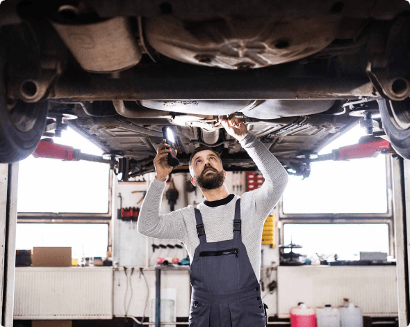 a man looking under a vehicle