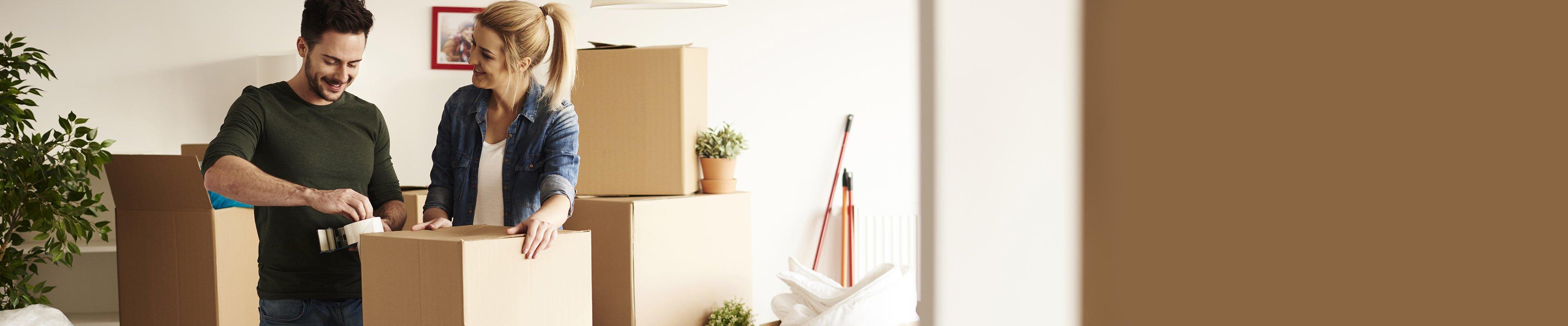 Young couple packing boxes to move.