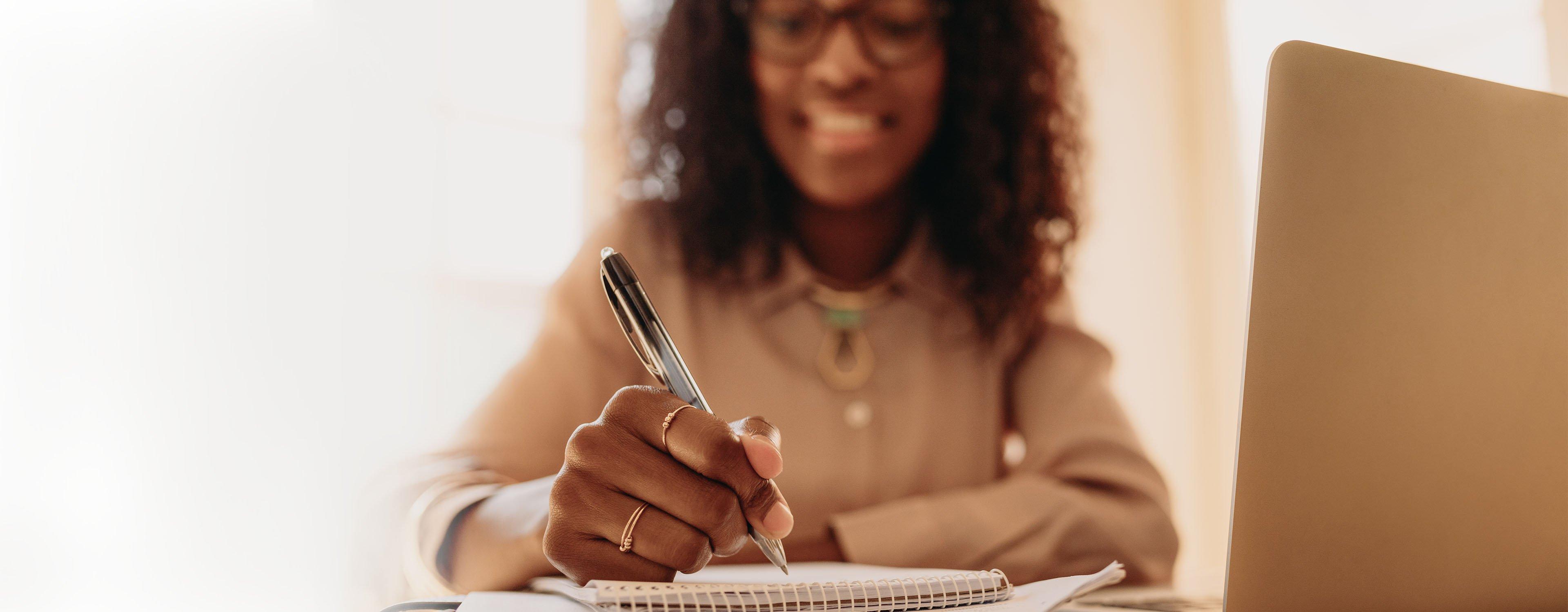 a woman writing on a piece of paper