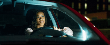 a woman driving a car at night