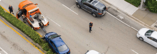 a person standing on the side of a road with cars and a truck