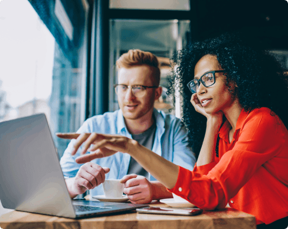 Two business owners looking at a laptop while talking.