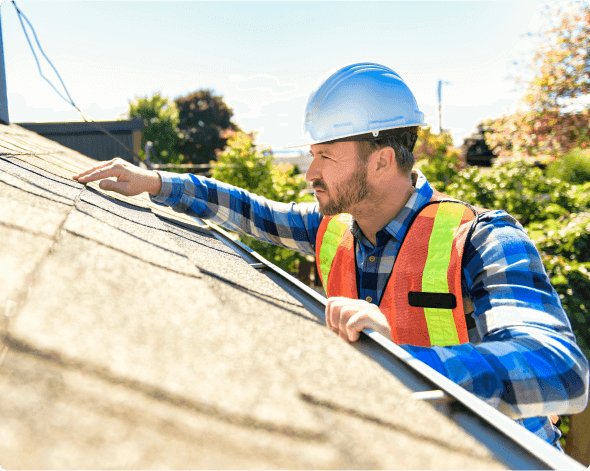 a man wearing a hard hat and safety vest pointing at a piece of wood