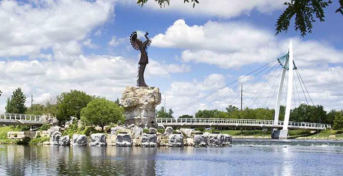 a statue on a rock in the middle of a body of water