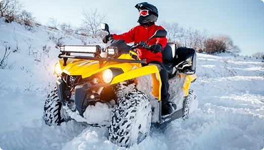 a person riding an atv in the snow